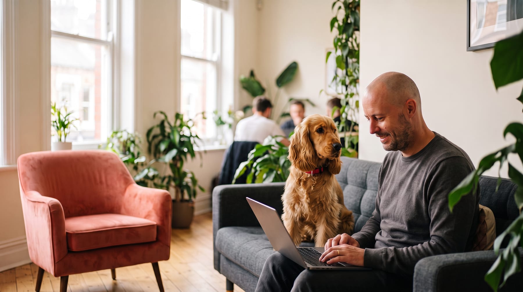 Maxime Baqué travaille sur son ordinateur avec son chien Vasco, dans un espace de coworking lumineux